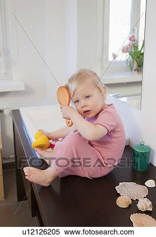 Stock Photography - Toddler girl brushing her hair. Fotosearch