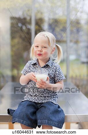 Toddler girl holding glass of milk View Large Photo Image Stock Image - Toddler girl holding glass of milk. Fotosearch