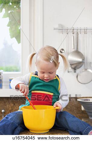 Stock Photography - Toddler girl mixing ingredients. Fotosearch