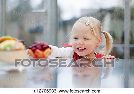 Toddler girl reaching for fruit cakes View Large Photo Image Stock Image - Toddler girl reaching for fruit cakes. Fotosearch