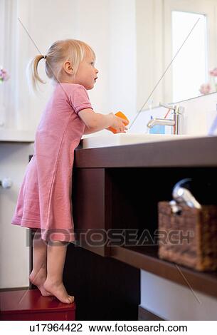 Stock Image - Toddler girl washing her hands. Fotosearch
