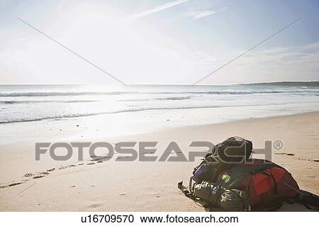 Stock Image - Two backpacks laid down on the beach. Fotosearch