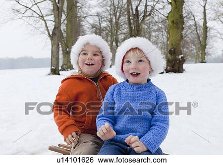 Two boys wearing fluffy hats in the snow View Large Photo Image Stock Photograph - Two boys wearing fluffy hats in the snow. Fotosearch