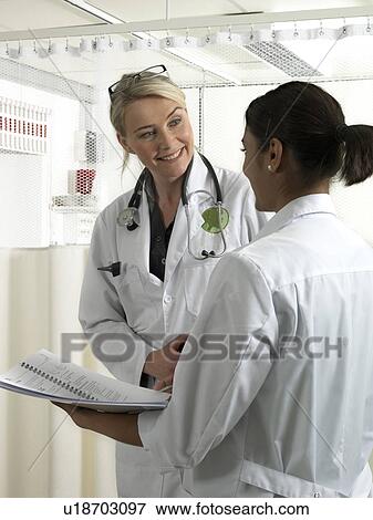 Two doctors discussing View Large Photo Image Stock Photo - Two doctors discussing. Fotosearch