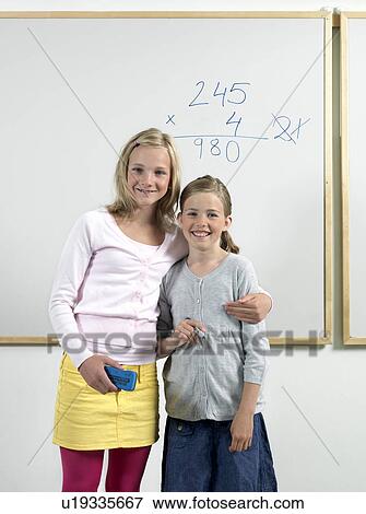 Two girls by whiteboard View Large Photo Image Stock Photo - Two girls by whiteboard. Fotosearch