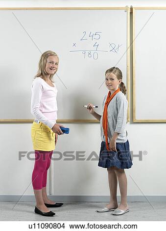 Two girls standing by the whiteboard View Large Photo Image Picture - Two girls standing by the whiteboard. Fotosearch