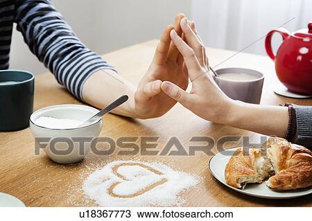 Stock Image - Two hands touching over table. Fotosearch