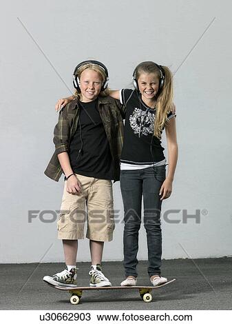 Two kids on a skateboard View Large Photo Image Stock Image - Two kids on a skateboard. Fotosearch
