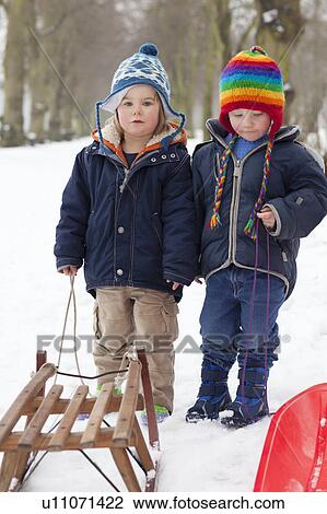 Two little boys in the snow View Large Photo Image Stock Image - Two little boys in the snow. Fotosearch