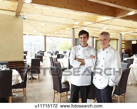 Two proud chefs in a large restaurant View Large Photo Image Stock Image - Two proud chefs in a large restaurant. Fotosearch