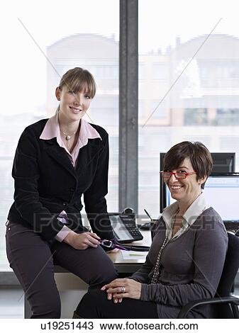 Two Women looking over some paper work in an Office View Large Photo Image Stock Image - Two Women looking over some paper work in an Office. Fotosearch