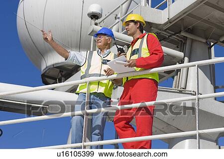 Stock Photo - Two workers standing on guardrail. Fotosearch