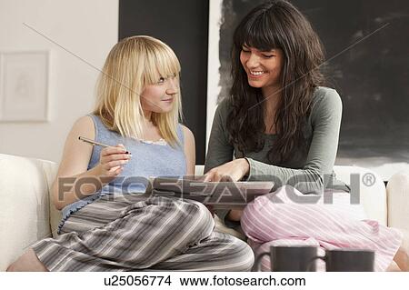 Two young women job-hunting in newspaper View Large Photo Image Picture - Two young women job-hunting in newspaper. Fotosearch