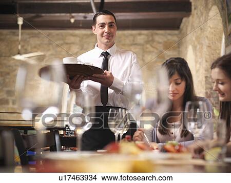 Waiter serving people in restaurant View Large Photo Image Picture - Waiter serving people in restaurant. Fotosearch