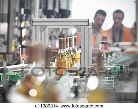 Wine bottles in bottling machine View Large Photo Image Picture - Wine bottles in bottling machine. Fotosearch