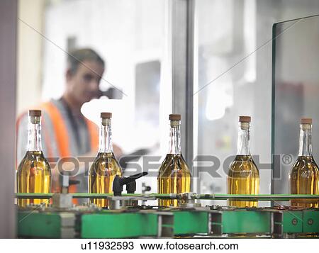 Wine bottles in bottling machine View Large Photo Image Stock Image - Wine bottles in bottling machine. Fotosearch