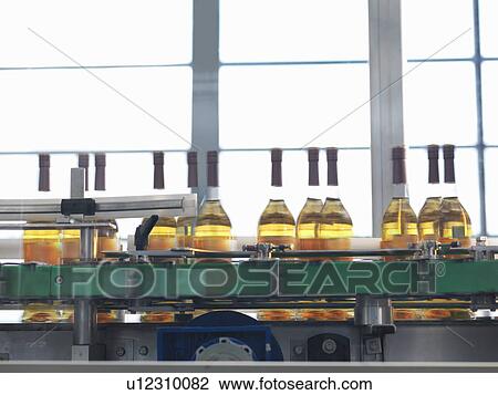 Wine bottles in bottling machine View Large Photo Image Stock Image - Wine bottles in bottling machine. Fotosearch