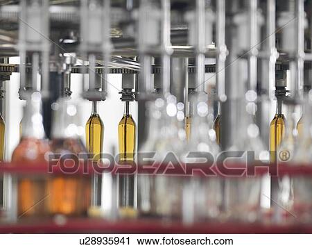 Wine bottles in bottling machine View Large Photo Image Stock Image - Wine bottles in bottling machine. Fotosearch