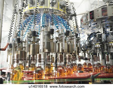 Stock Photo - Wine bottles in bottling machine. Fotosearch