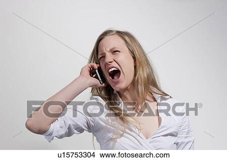 Picture - Woaen with cellphone screaming. Fotosearch