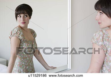 Woman admiring herself in mirror View Large Photo Image Stock Photograph - Woman admiring herself in mirror. Fotosearch