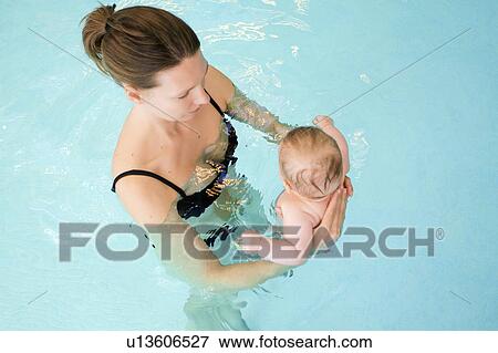Stock Photo - Woman and baby in swimming pool. Fotosearch