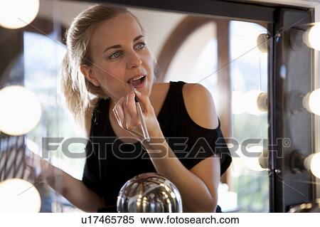 Woman applying lipstick using mirror View Large Photo Image Stock Photography - Woman applying lipstick using mirror. Fotosearch