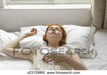 Stock Photography - woman asleep on bed. Fotosearch