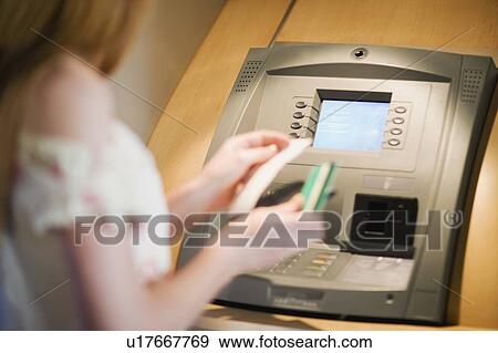 Stock Photo - Woman at a cashpoint. Fotosearch