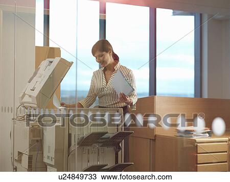 Stock Image - Woman at photocopier. Fotosearch