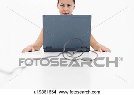 Picture - Woman at table with laptop. Fotosearch