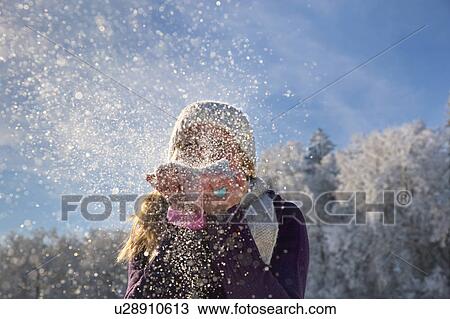 Stock Image - Woman blowing snow at viewer. Fotosearch