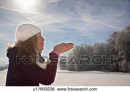 Stock Photo - Woman blowing snow from hands. Fotosearch