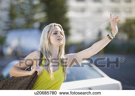Stock Image - Woman calling a cab. Fotosearch