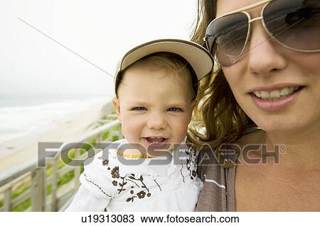 Woman carrying baby girl on beach View Large Photo Image Stock Image - Woman carrying baby girl on beach. Fotosearch