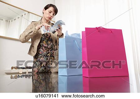 Stock Image - woman checking money from purse. Fotosearch