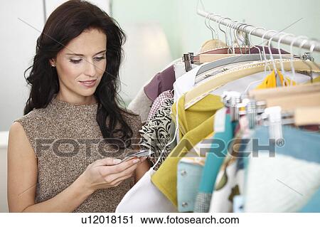 Stock Image - woman checking price tag. Fotosearch