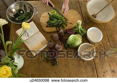 Woman chopping vegetables in kitchen View Large Photo Image Stock Photo - Woman chopping vegetables in kitchen. Fotosearch