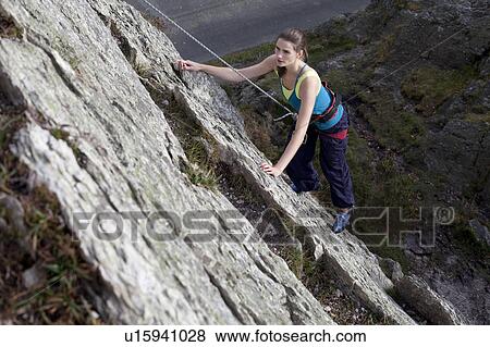 Stock Photo - woman climbing a rockface . Fotosearch
