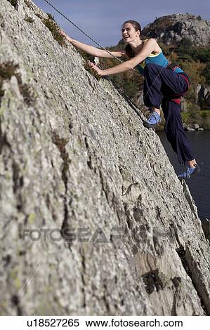 Stock Photography - woman climbing a rockface . Fotosearch