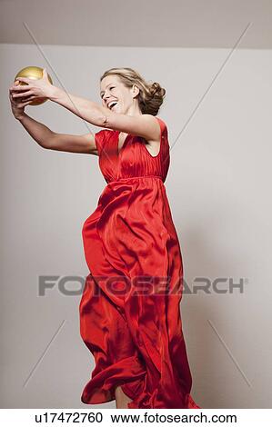 Stock Image - Woman dancing with a golden ball. Fotosearch