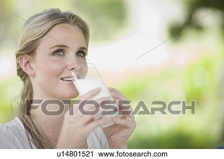 Stock Image - Woman drinking a glass of milk. Fotosearch