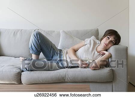 Stock Photograph - Woman drinking wine on couch. Fotosearch