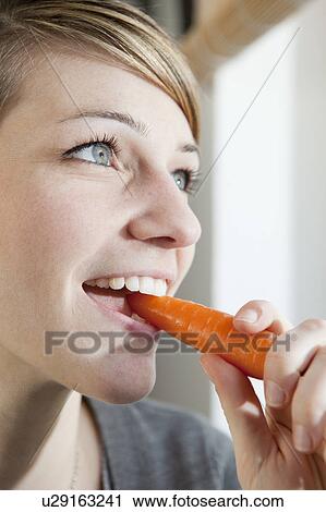 Woman eating a carrot View Large Photo Image Stock Image - Woman eating a carrot. Fotosearch