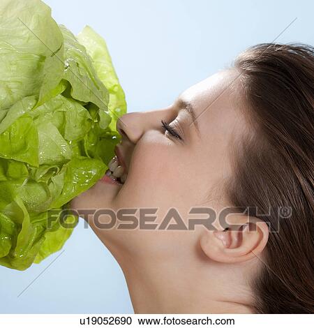 Woman eating a head of lettuce View Large Photo Image Stock Image - Woman eating a head of lettuce. Fotosearch
