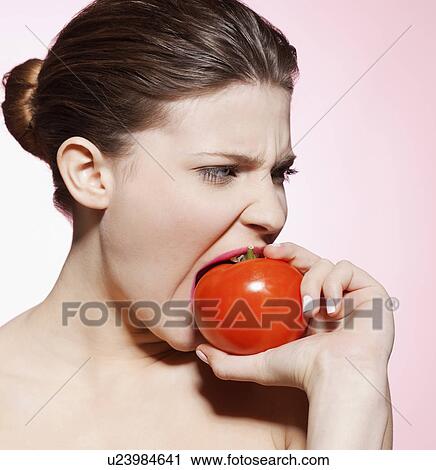 Woman eating a tomato View Large Photo Image Stock Image - Woman eating a tomato. Fotosearch