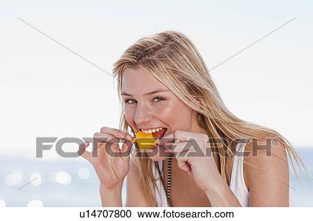 Woman eating popsicle on beach View Large Photo Image Stock Image - Woman eating popsicle on beach. Fotosearch