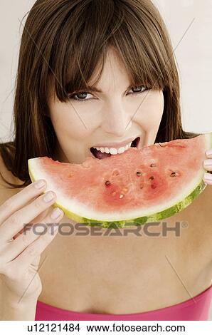 Picture - Woman eating watermelon. Fotosearch