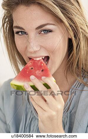 Picture - Woman eating watermelon. Fotosearch