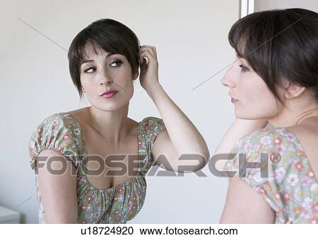 Woman examining hair in mirror View Large Photo Image Stock Image - Woman examining hair in mirror. Fotosearch